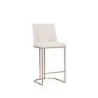 A modern upholstered counter stool with a curved brass-finished metal base and light neutral fabric seat and back.