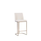 A modern upholstered counter stool with a curved brass-finished metal base and light neutral fabric seat and back.