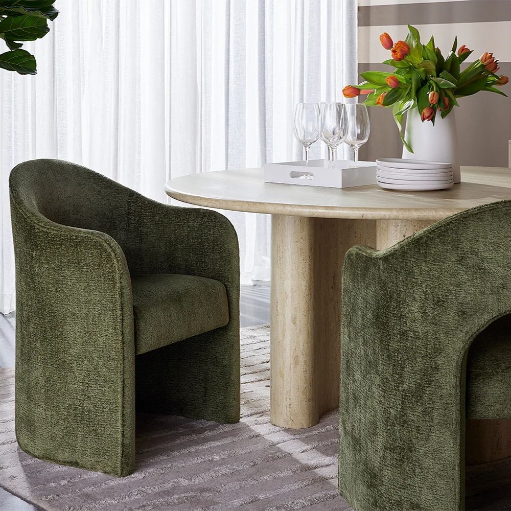 Anaya Dining Armchair in rich forest green velvet with a sculptural arch-back silhouette and solid base design.