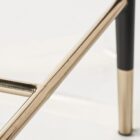 Asher counter stool with upholstered seat and backrest, black tapered legs, and gold foot caps.