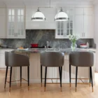 Asher counter stool with upholstered seat and backrest, black tapered legs, and gold foot caps.