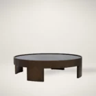 Large round coffee table with dark wood finish and sculptural base design, featuring a recessed top.
