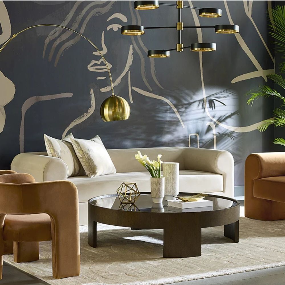 Large round coffee table with dark wood finish and sculptural base design, featuring a recessed top.