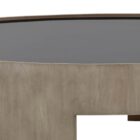 Round coffee table with light wood base and dark recessed top, featuring sculptural curved legs.