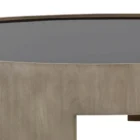Round coffee table with light wood base and dark recessed top, featuring sculptural curved legs.