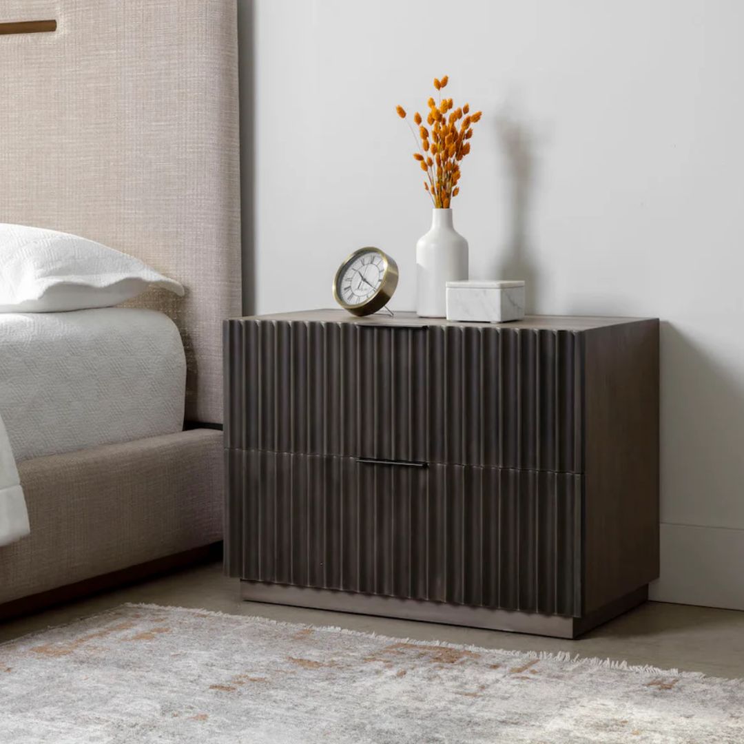 Dark wood nightstand with distinctive vertical fluted drawer fronts and a minimalist rectangular silhouette.