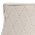 Elegant stool with soft beige upholstered seat and curved gold metal base.