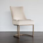 Elegant stool with soft beige upholstered seat and curved gold metal base.