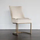 Elegant stool with soft beige upholstered seat and curved gold metal base.