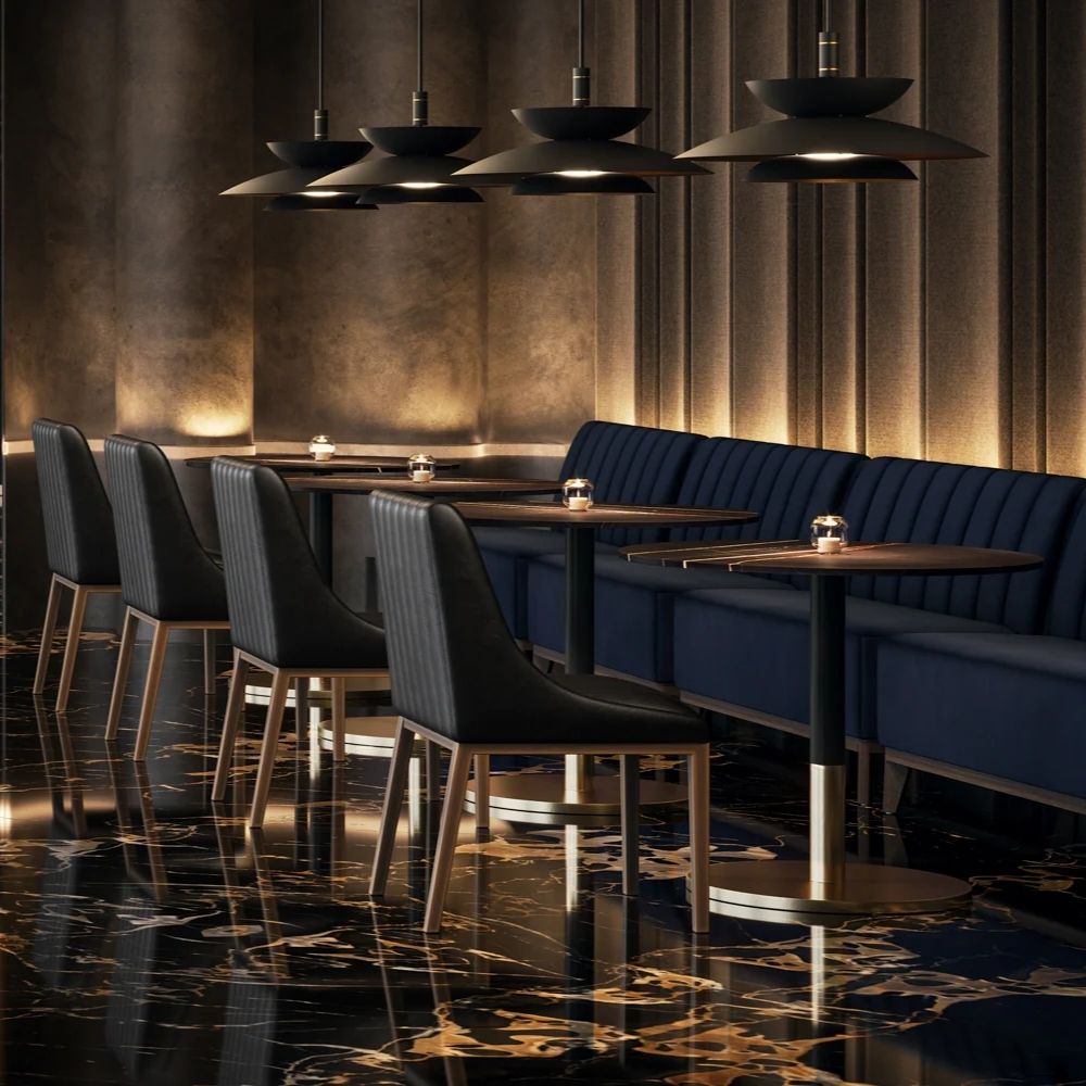 Black leather dining chair with vertical channel stitching, arched backrest, and slim brass-toned legs.