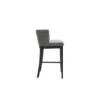 Dark grey upholstered barstool with low backrest and black wooden legs, styled beside a light wood countertop in a neutral-toned interior.