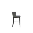 Dark grey upholstered barstool with low backrest and black wooden legs, styled beside a light wood countertop in a neutral-toned interior.
