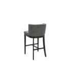 Dark grey upholstered barstool with low backrest and black wooden legs, styled beside a light wood countertop in a neutral-toned interior.