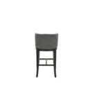 Dark grey upholstered barstool with low backrest and black wooden legs, styled beside a light wood countertop in a neutral-toned interior.