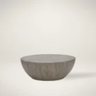 Small round concrete coffee table with a curved bowl-like base and smooth grey finish.