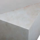Square concrete coffee table with angular crack-inspired detail and softly weathered stone texture.
