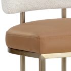 A modern Larissa Stool featuring a warm caramel leather seat, curved white boucle backrest, and slim brushed brass metal frame.