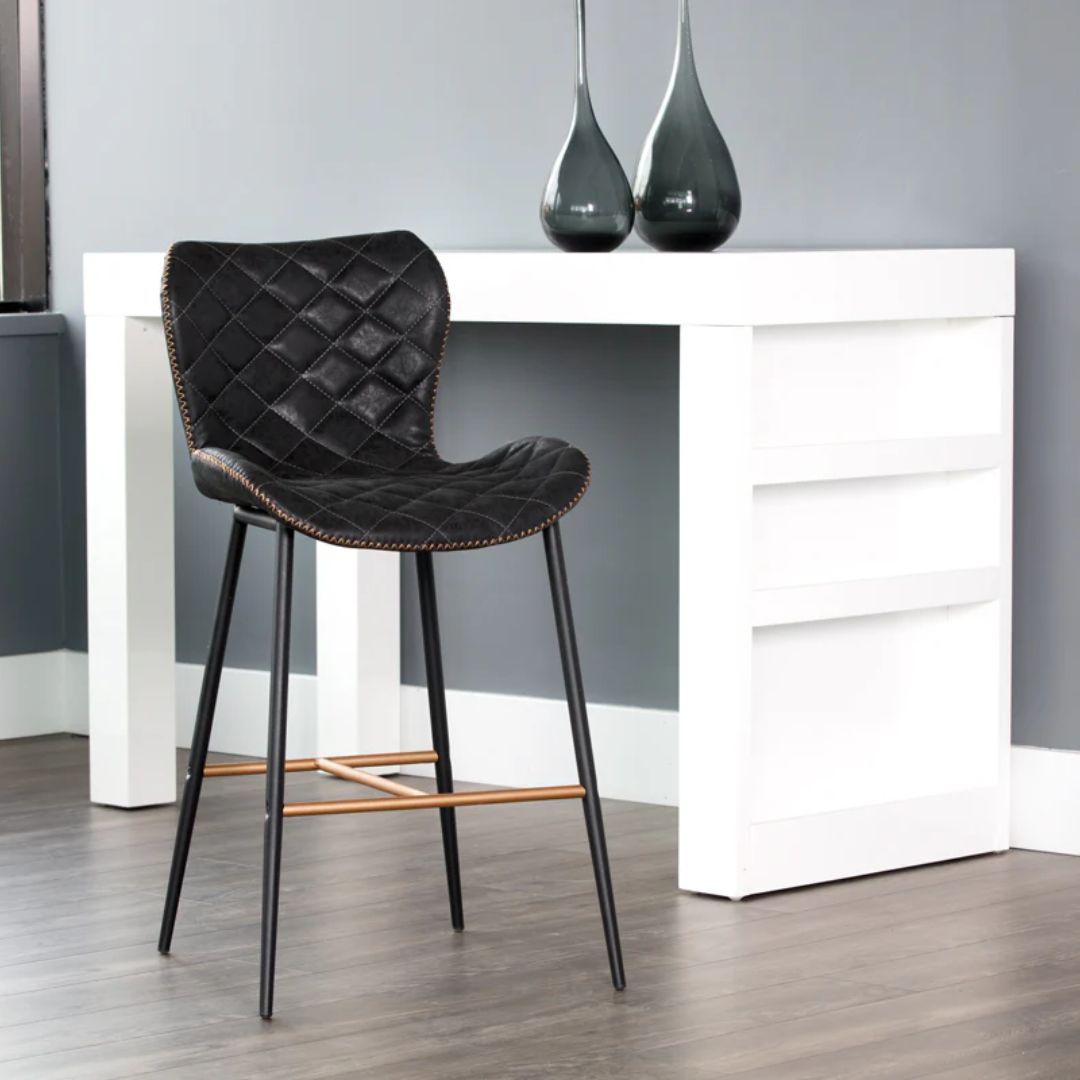 Diamond-stitched black leather seat upholstery, with quilted seat and brass footrest.