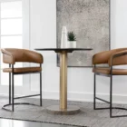 Modern counter stool featuring a curved saddle leather backrest, cushioned seat, and sleek black metal frame with an arched footrest.