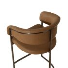Modern counter stool featuring a curved saddle leather backrest, cushioned seat, and sleek black metal frame with an arched footrest.