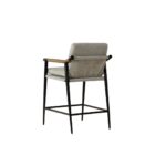 Meadow Counter Stool highlighting the curved backrest, textured upholstery, and sleek black frame with integrated wooden armrests.