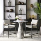 Meadow Counter Stool highlighting the curved backrest, textured upholstery, and sleek black frame with integrated wooden armrests.