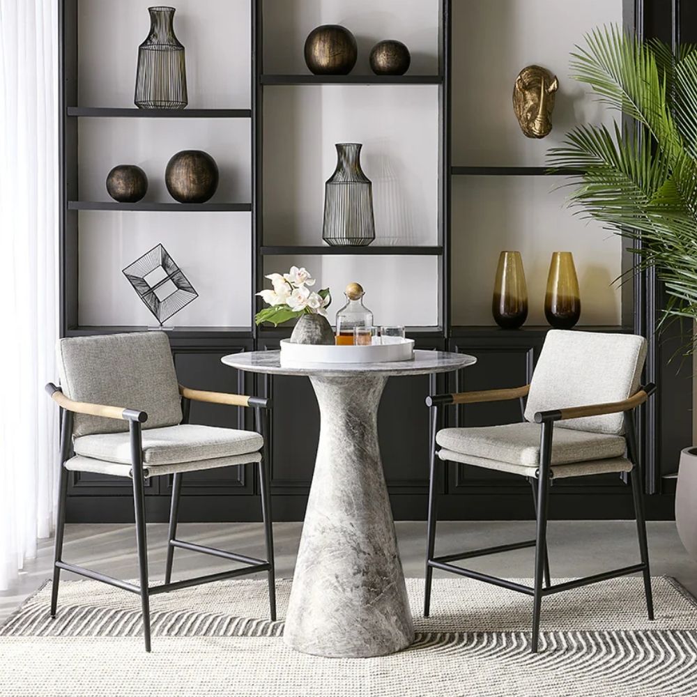 Meadow Counter Stool highlighting the curved backrest, textured upholstery, and sleek black frame with integrated wooden armrests.