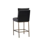 Paige Counter Stool featuring a black faux leather upholstered seat and loose-style back cushion, set on a brushed metal frame with footrest