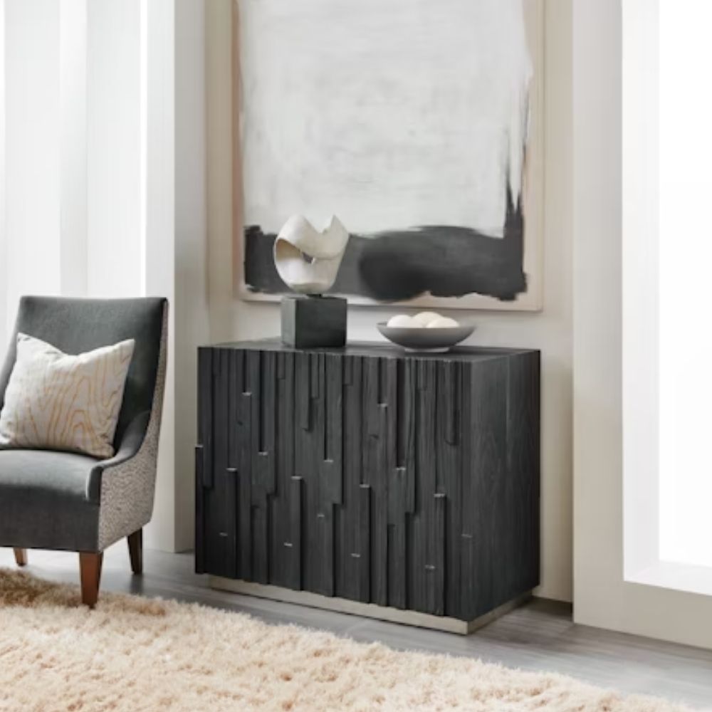 Small black accent chest with vertical wood texture and charred Shou Sugi Ban finish, resting on a subtle metallic plinth.