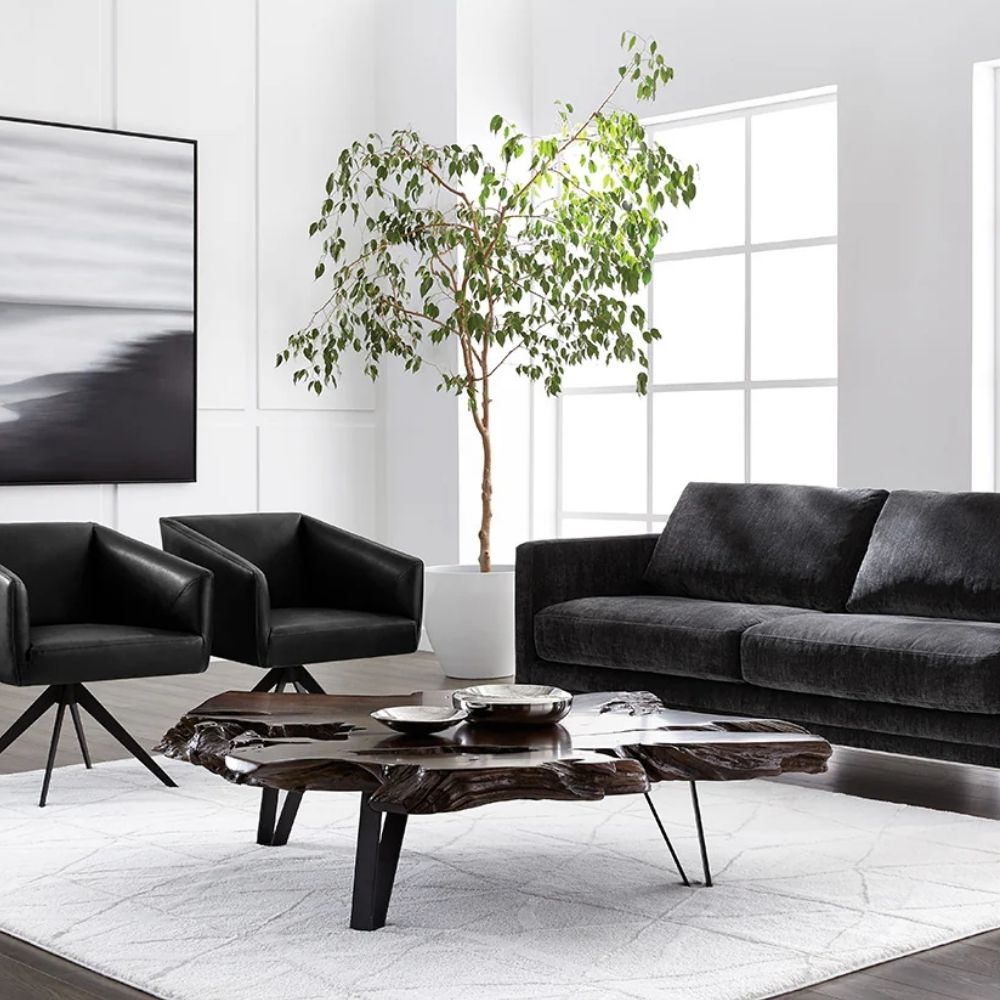 Live-edge sculptural coffee table crafted from dark natural teak wood with organic curves and black angular legs.