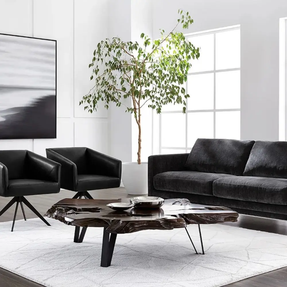 Live-edge sculptural coffee table crafted from dark natural teak wood with organic curves and black angular legs.