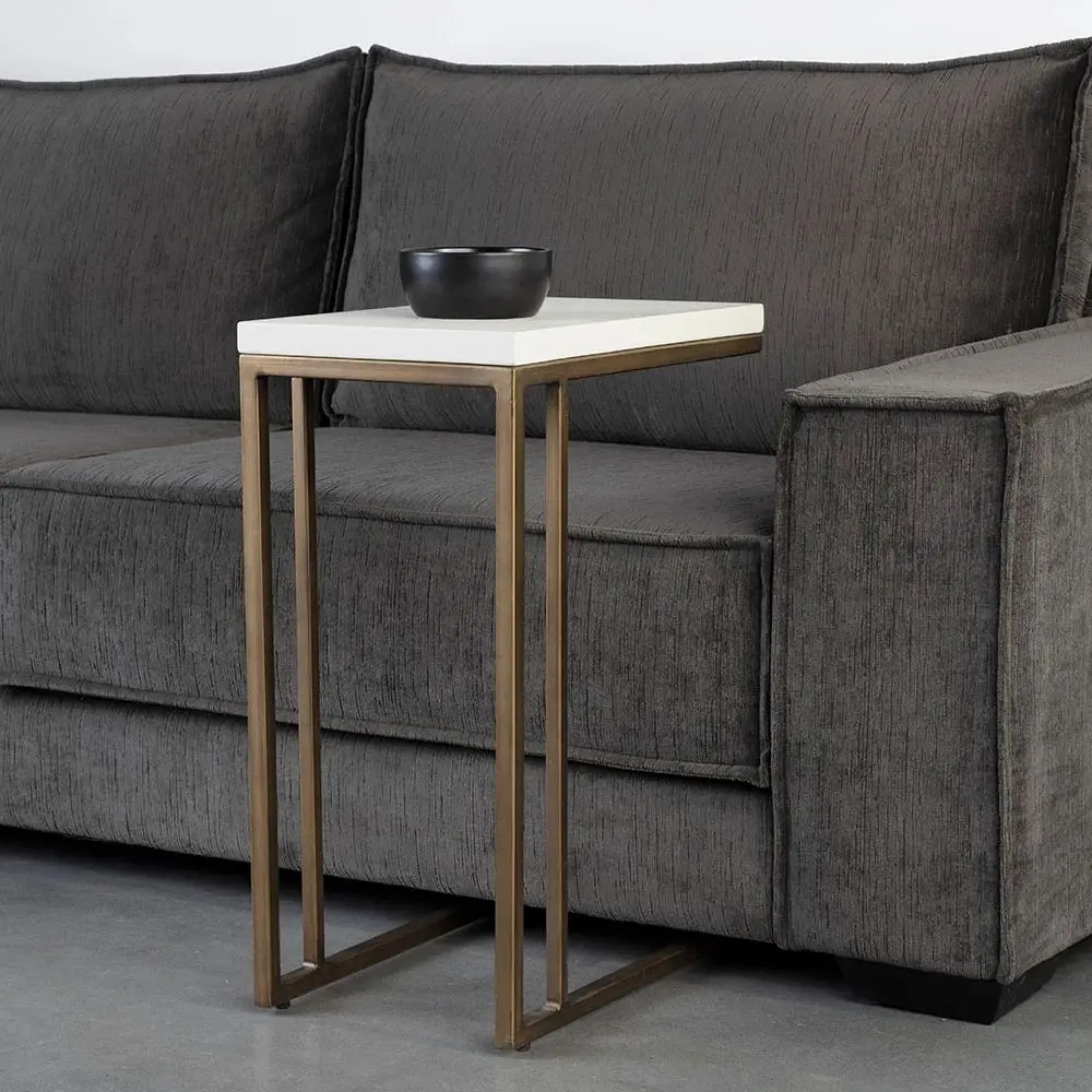 Modern white C-shaped end table with a thin metal base in a bronze finish and a sleek white top.