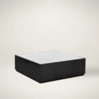 Modern square coffee table with a sleek black base and white marble top, featuring minimalist cube styling.