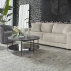 Round black coffee table with slim metal frame, lower glass shelf, and gold-dipped leg tips.