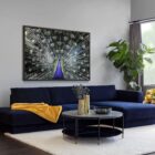 Round black coffee table with slim metal frame, lower glass shelf, and gold-dipped leg tips.