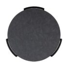 Round modern end table with black textured top, slim black legs, lower shelf, and brass-capped feet.