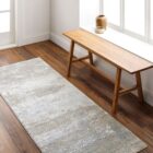 Brunswick Machine Woven Rug in soft greys, creams, and beige tones with a distressed abstract pattern.