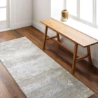 Brunswick Machine Woven Rug in soft greys, creams, and beige tones with a distressed abstract pattern.
