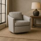Modern light grey upholstered swivel chair with angled arms and a rounded base.
