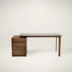 Modern desk with walnut drawers and a floating dark glass top, featuring a minimalist silhouette and integrated storage.