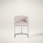 Front and side view of an elegant modern counter stool with a curved backrest, upholstered in a light neutral fabric with sleek metallic legs and a rounded base.