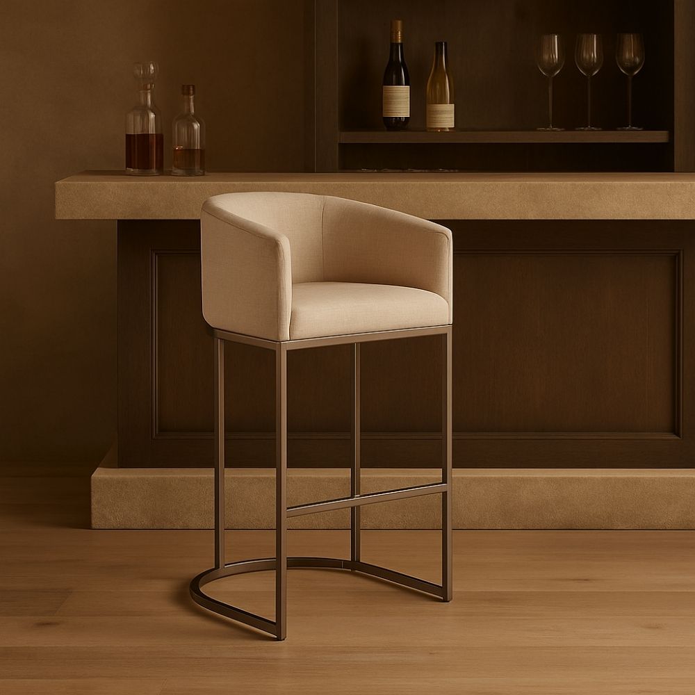 Front and side view of an elegant modern counter stool with a curved backrest, upholstered in a light neutral fabric with sleek metallic legs and a rounded base.