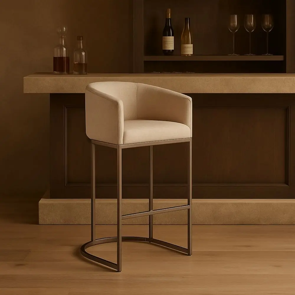 Front and side view of an elegant modern counter stool with a curved backrest, upholstered in a light neutral fabric with sleek metallic legs and a rounded base.