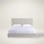 Upholstered bed with vertical channel tufting and minimalist frame.