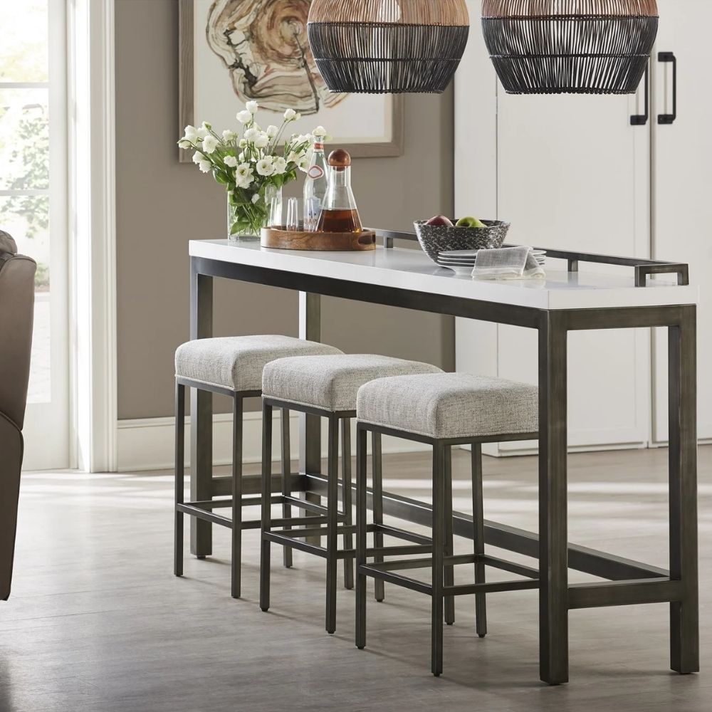 Contemporary console table with white top, gunmetal frame, and three matching upholstered stools.