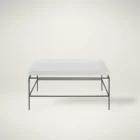 Rectangular white cocktail table with a raised-edge surface and slim black metal frame base.