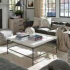 Rectangular white cocktail table with a raised-edge surface and slim black metal frame base.