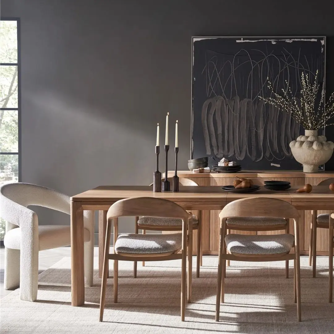 A minimalist rectangular wood dining table with soft-rounded edges and natural grain finish, shown in a studio-style background.