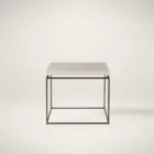 Minimalist end table with a white textured top and thin matte black metal frame.
