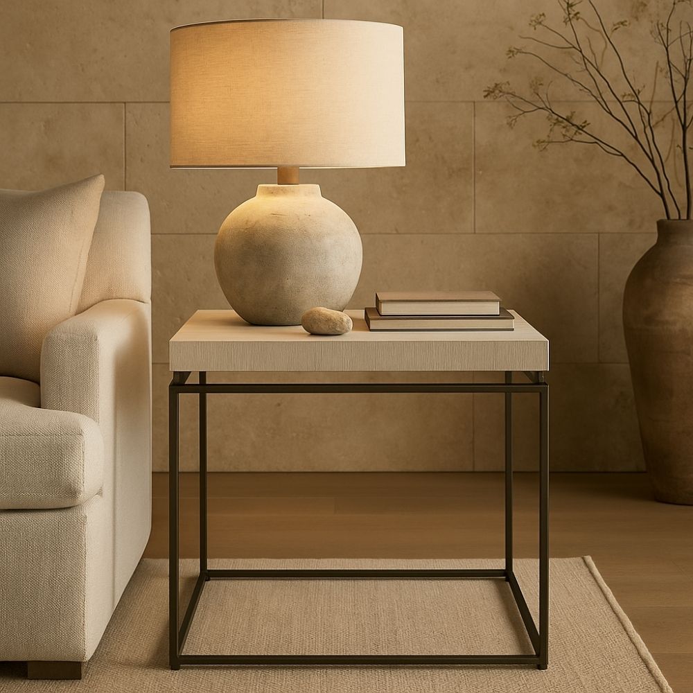 Minimalist end table with a white textured top and thin matte black metal frame.